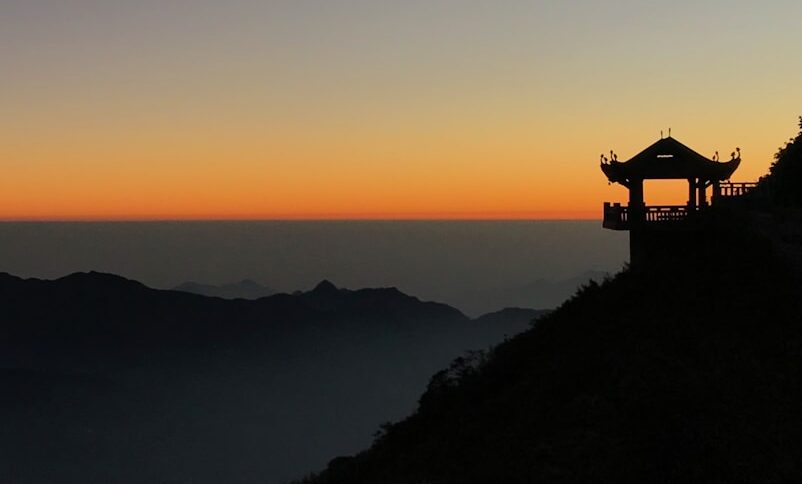 silhouette of tori building near mountain